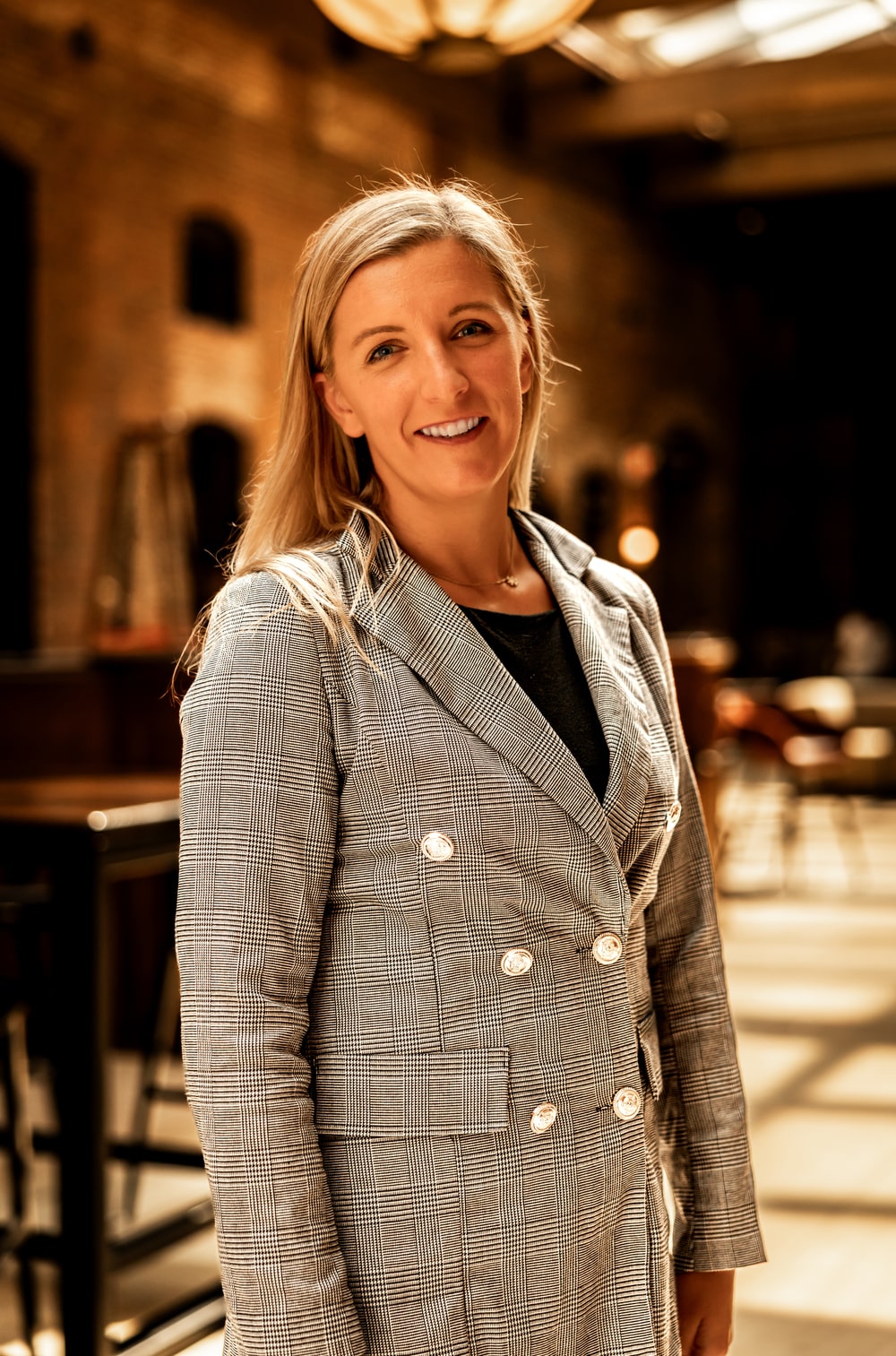 Regan Kulhavy attorney at the Law Office of Will M. Helixon wearing a plaid blazer in a warmly lit office interior