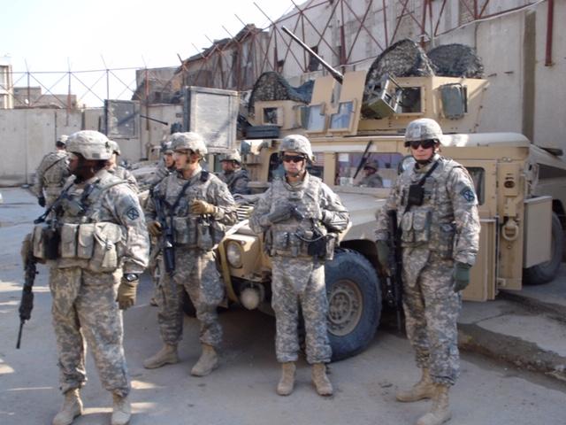 Andre Le Blanc in military uniform with soldiers standing by armored HMMWV vehicle