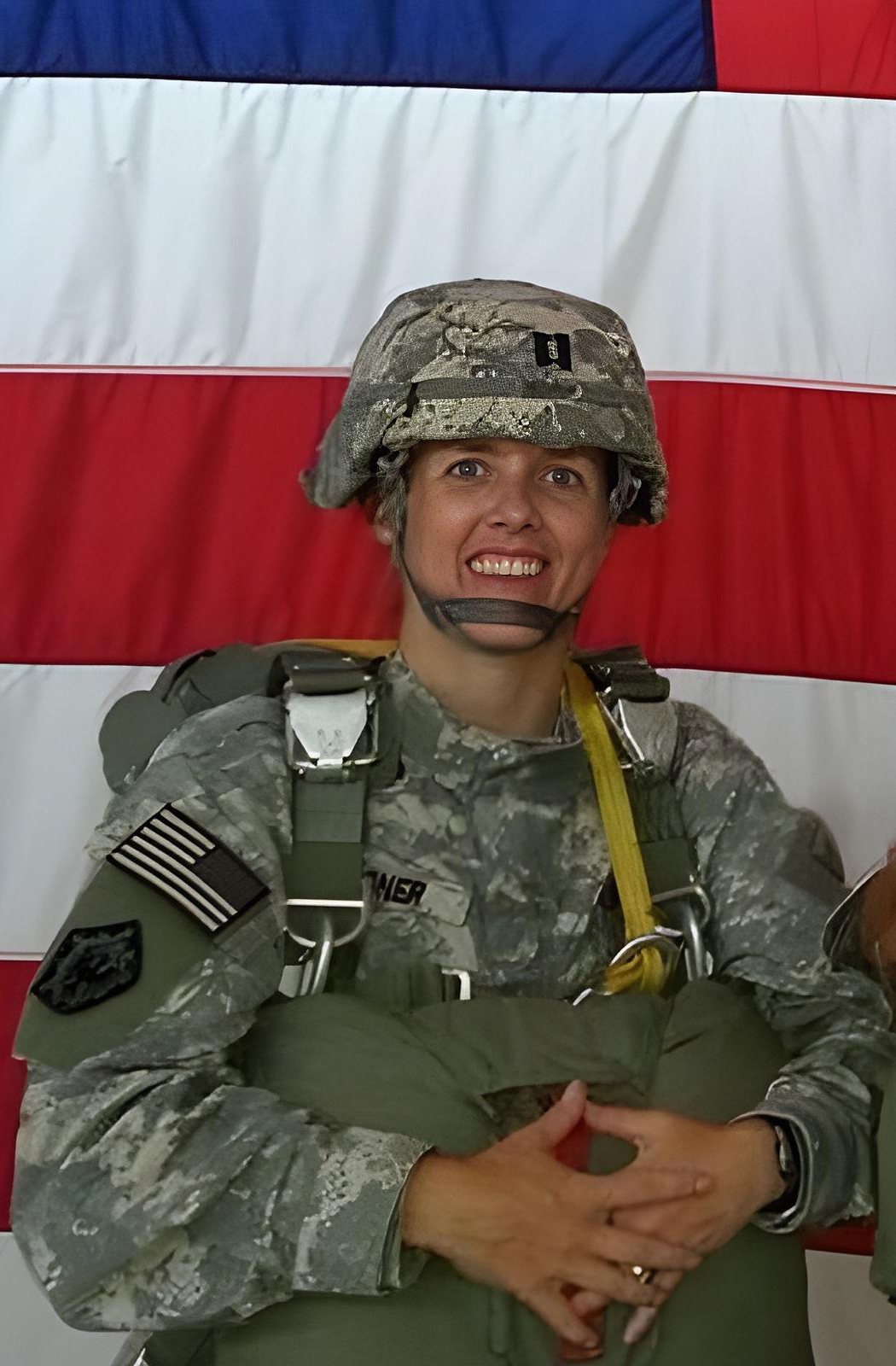 Kyle Meisner in Army jump gear and helmet with American flag background