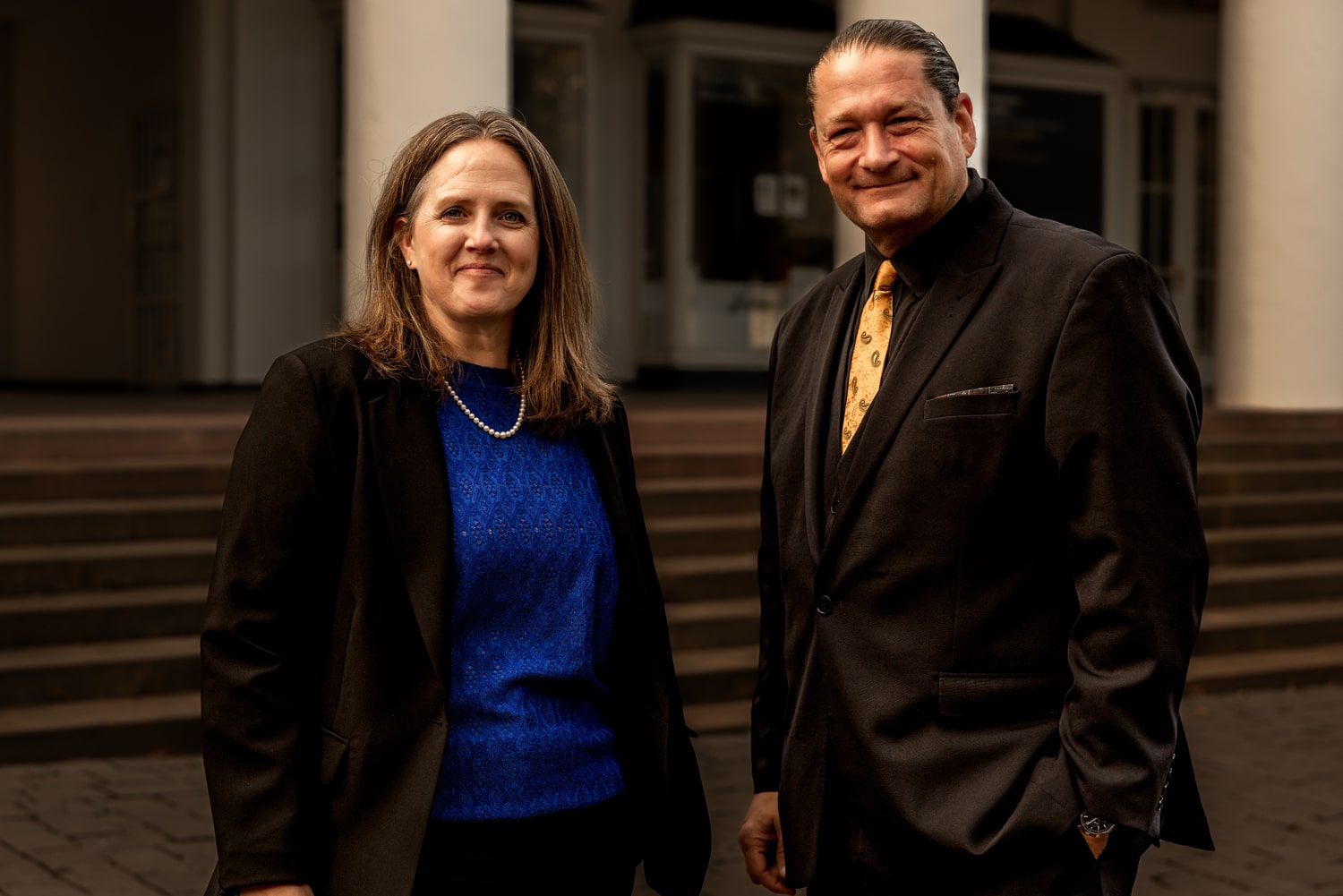 Kyle Meisner with Will M. Helixon, both in formal attire, standing together outdoors near steps