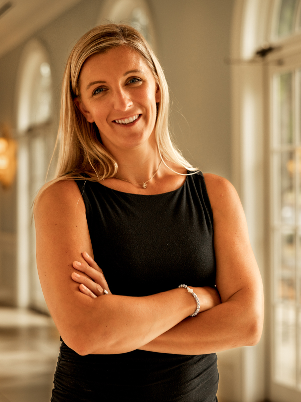 Military attorney Regan Kulhavy standing with arms crossed in black top