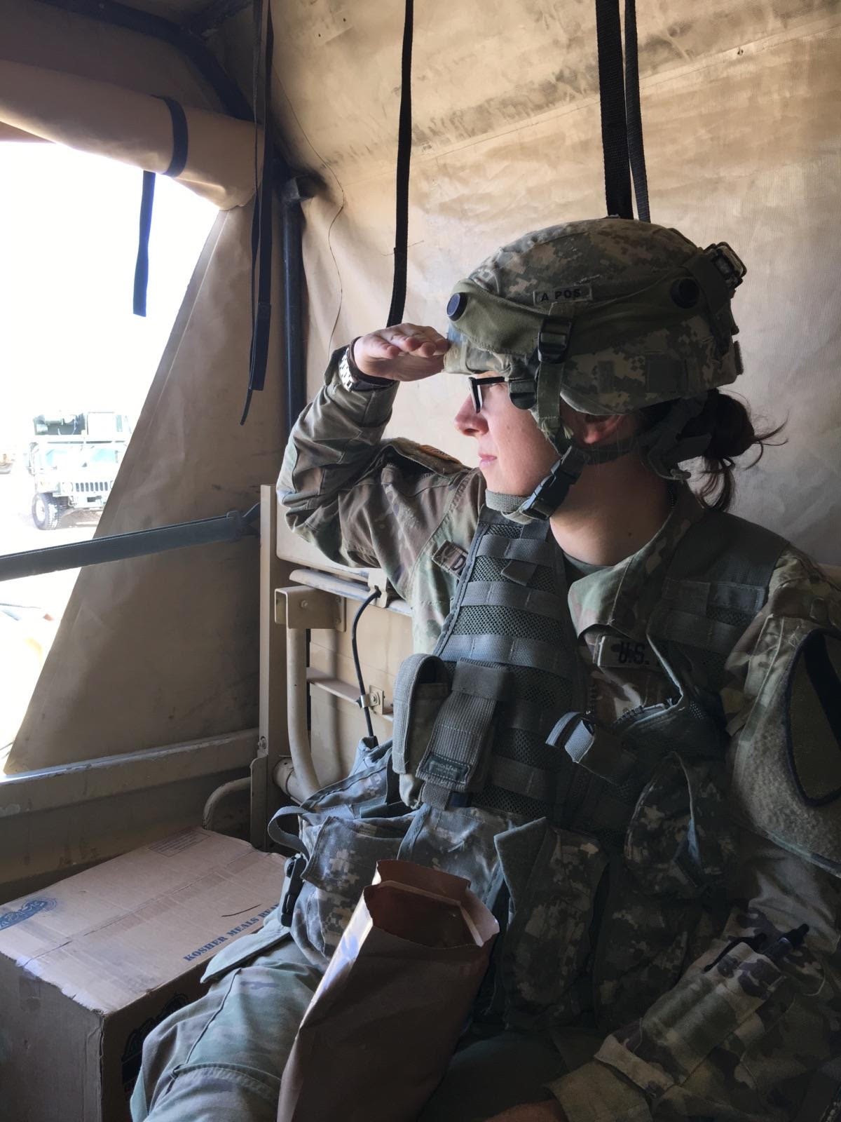 Natalia Helmsing saluting in military uniform inside an aircraft