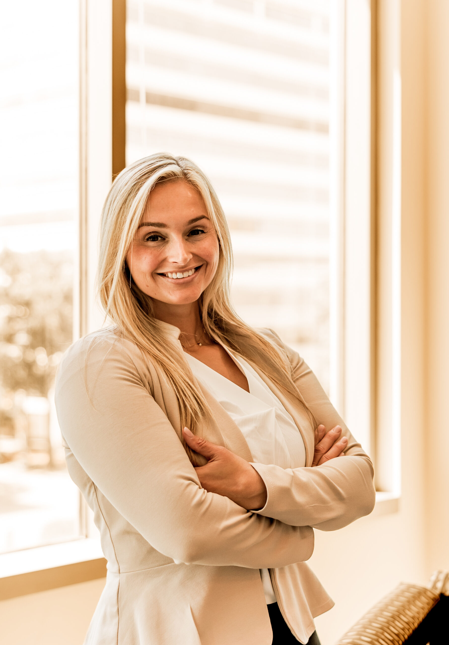 Stefany Garrick smiling with arms crossed inside an office