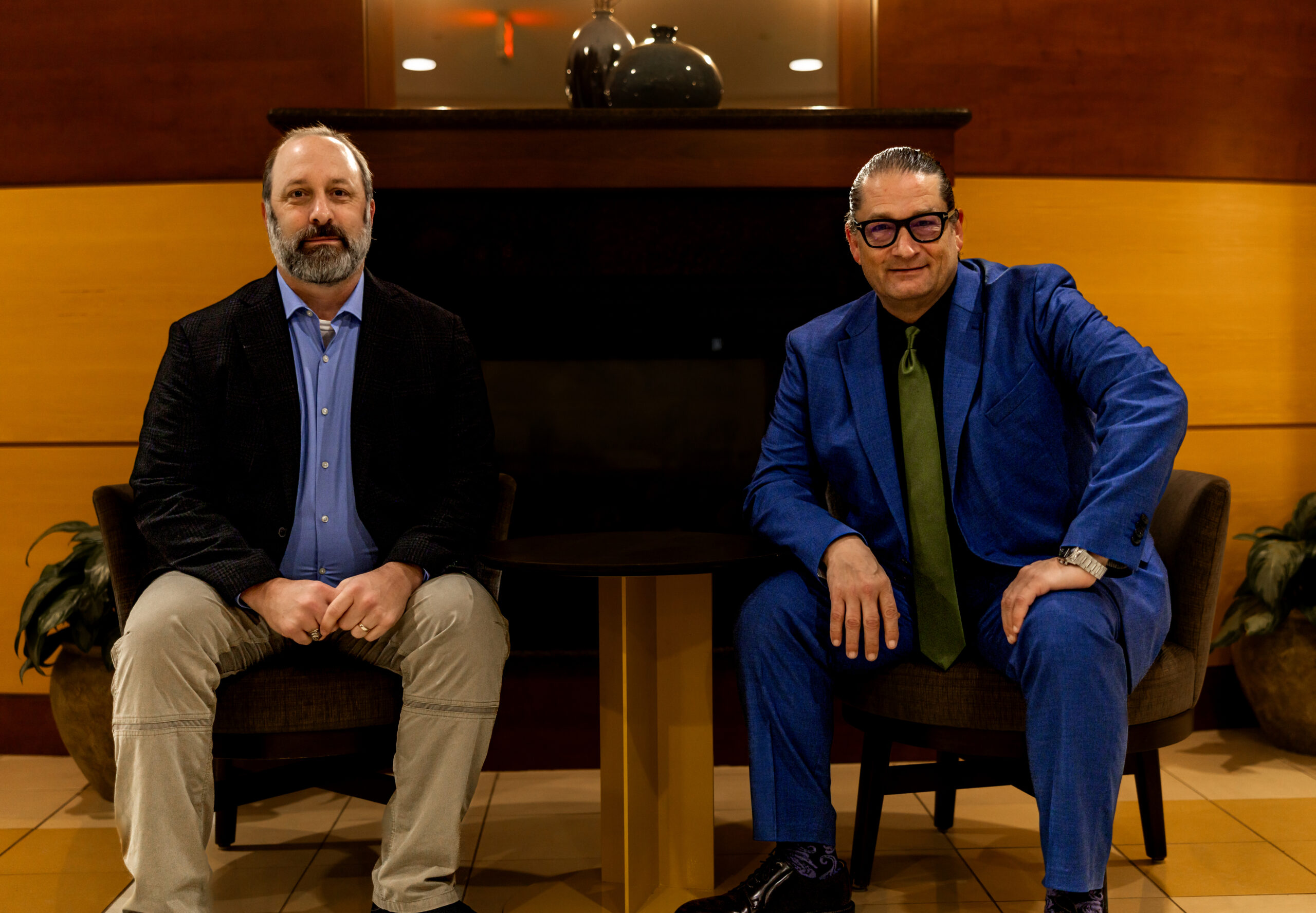 Treb Courie and Will M. Helixon sitting together in a business lounge