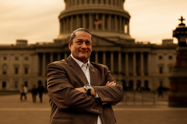Will M. Helixon, founder of the Law Office of Will M. Helixon, standing with arms crossed in front of the U.S. Capitol in Washington, D.C.