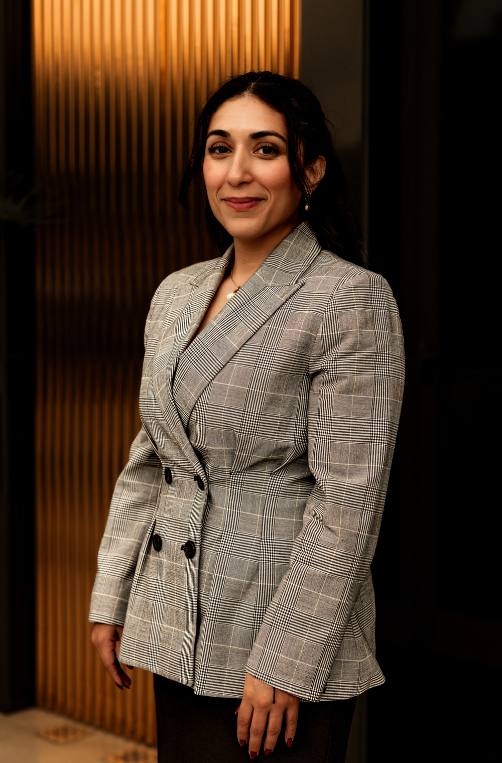 Headshot of military defense attorney Linda Aguilera in front of a warm wood wall